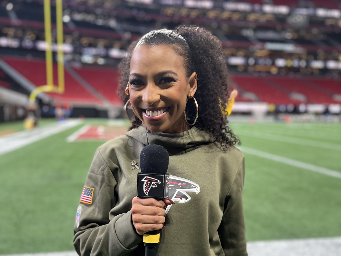 Chelsea on the field at Mercedes-Benz Stadium with a Falcons mic