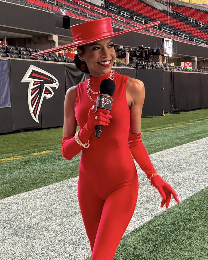 Chelsea on the Falcons sideline in a red jumpsuit and wide-brim hat